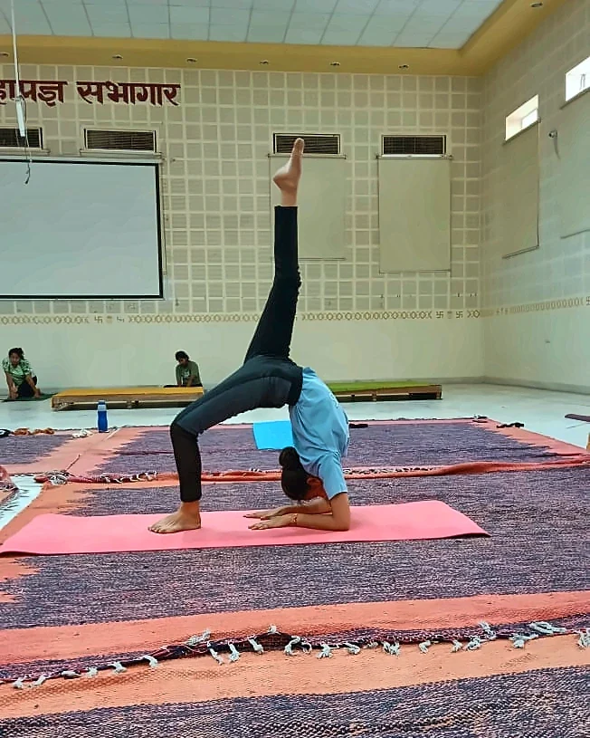 Latika, hall mein ek backbend asana karte hue