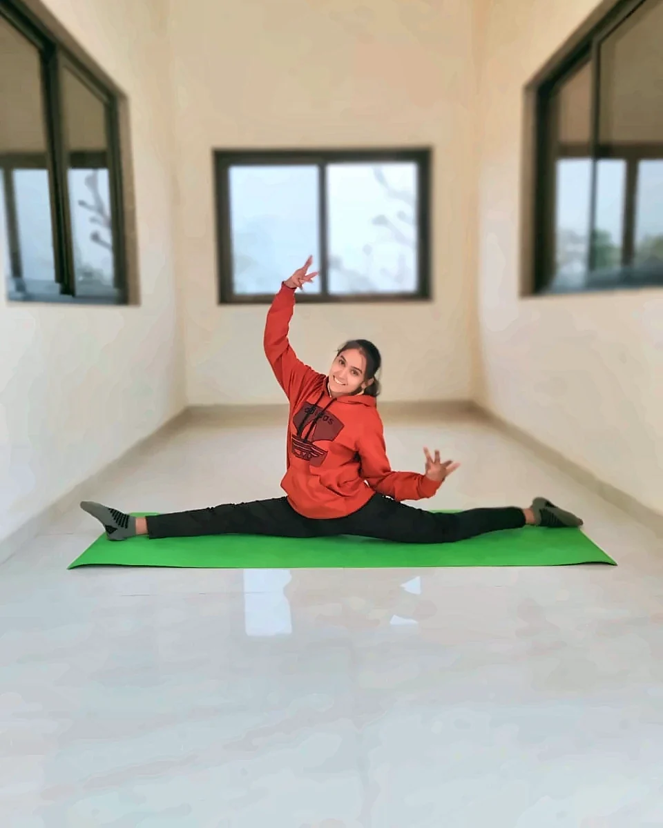 Latika, mat par split asana karte hue