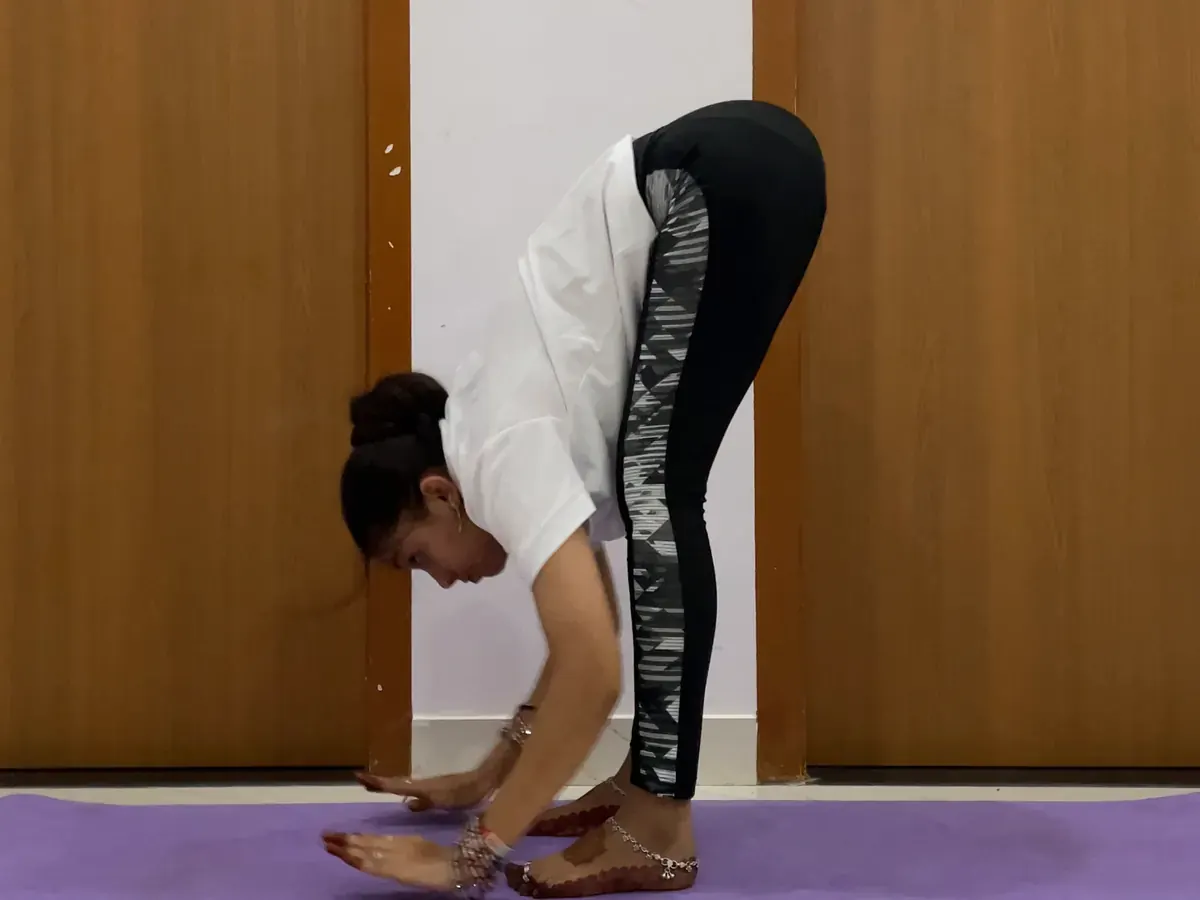 Latika Surya Namaskar ka Padahastasana step karte hue
